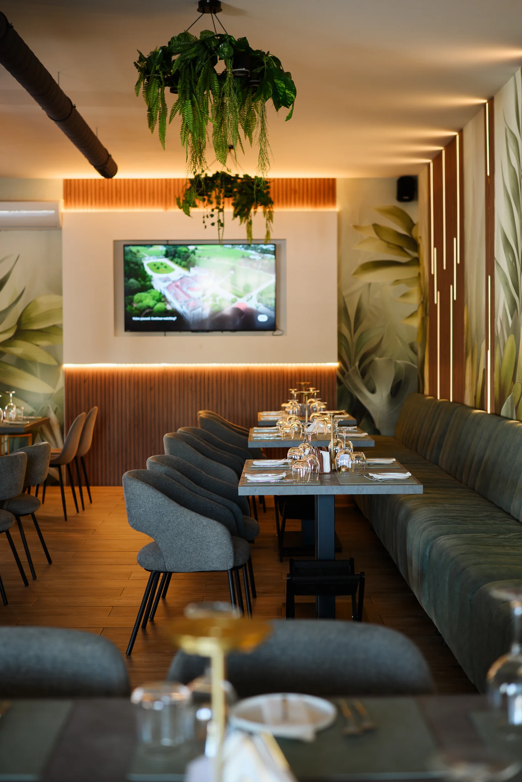 Ambiente interior do Catch Restaurante em Vilamoura, com plantas suspensas e mesas postas